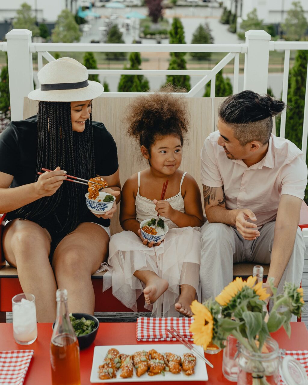 foster parents sitting with child on bench outdoors
